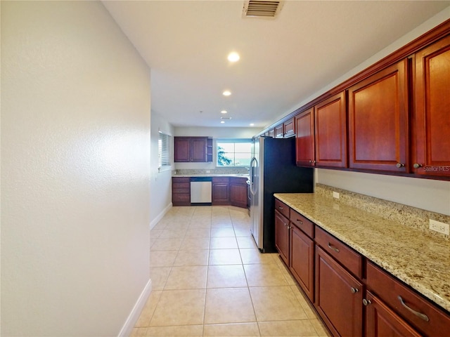 kitchen with light tile patterned floors, stainless steel appliances, and light stone counters