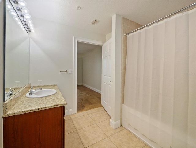 bathroom featuring tile patterned floors, a shower with curtain, vanity, and a textured ceiling