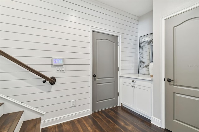 interior space featuring wood walls and dark hardwood / wood-style flooring