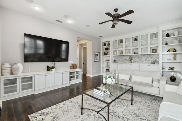 living room featuring ceiling fan and dark wood-type flooring