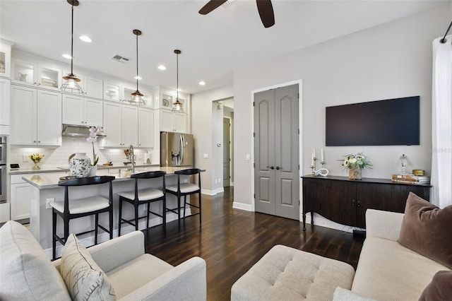 living room with ceiling fan and dark wood-type flooring