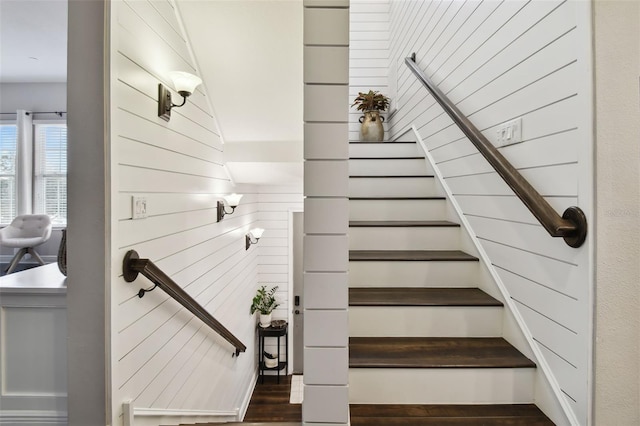 staircase with hardwood / wood-style flooring and wooden walls