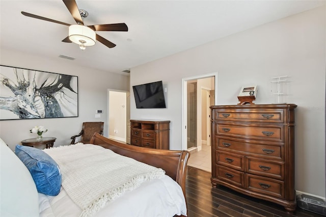 bedroom with dark hardwood / wood-style floors, ceiling fan, and connected bathroom