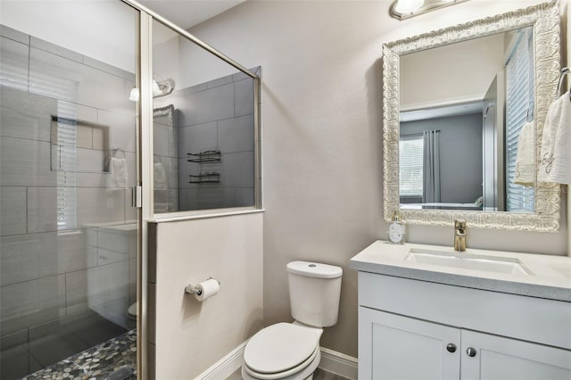 bathroom with vanity, toilet, and a shower with door