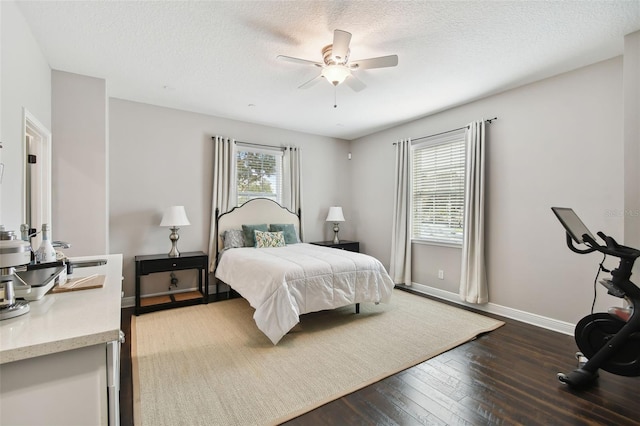 bedroom featuring a textured ceiling, dark hardwood / wood-style floors, and ceiling fan