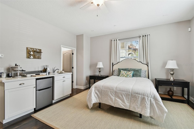 bedroom with stainless steel refrigerator, ceiling fan, sink, and dark wood-type flooring