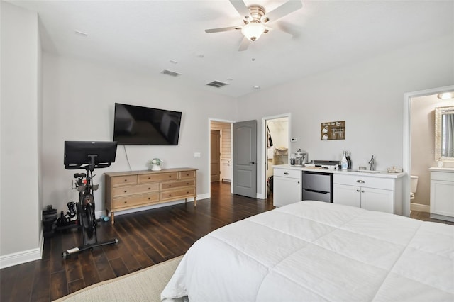 bedroom with stainless steel fridge, ensuite bathroom, ceiling fan, sink, and dark hardwood / wood-style floors