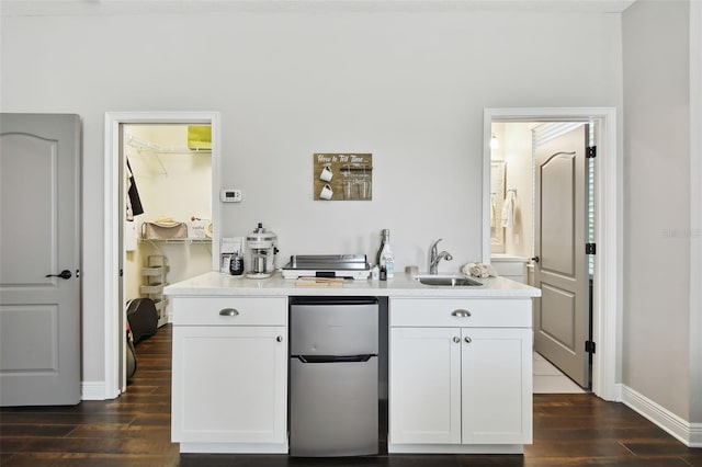 bar with dark hardwood / wood-style flooring, white cabinetry, and stainless steel refrigerator