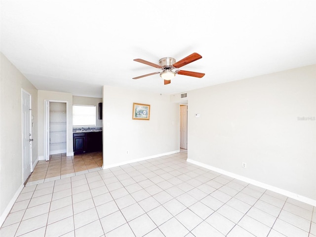 spare room with ceiling fan and light tile patterned flooring