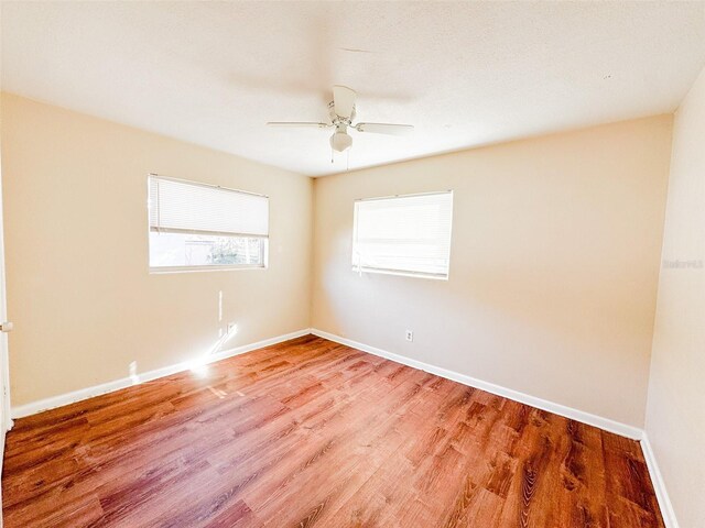 spare room with hardwood / wood-style floors and ceiling fan