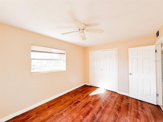 unfurnished bedroom featuring hardwood / wood-style flooring, ceiling fan, and a closet