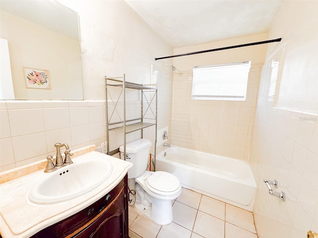 full bathroom featuring tiled shower / bath combo, tile patterned flooring, toilet, vanity, and tile walls