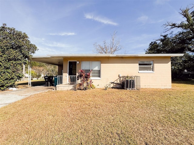 rear view of house featuring a carport and a lawn