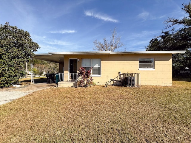 rear view of property featuring a carport and a yard