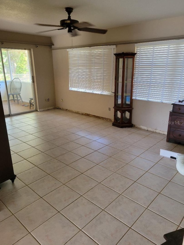 unfurnished living room with light tile patterned floors and a ceiling fan