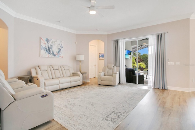 living room featuring hardwood / wood-style floors, ceiling fan, and crown molding