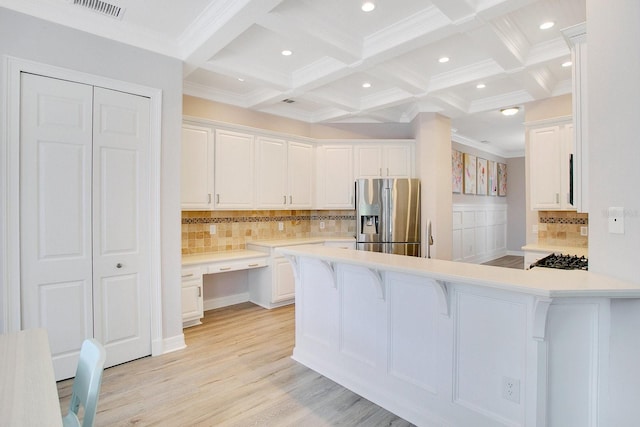 kitchen with beam ceiling, a kitchen breakfast bar, stainless steel fridge with ice dispenser, backsplash, and white cabinets