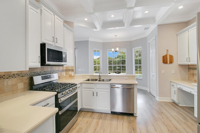 kitchen with kitchen peninsula, sink, white cabinets, and appliances with stainless steel finishes