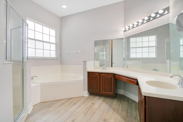 bathroom with independent shower and bath, vanity, and wood-type flooring