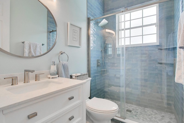 bathroom featuring vanity, toilet, and a shower with door