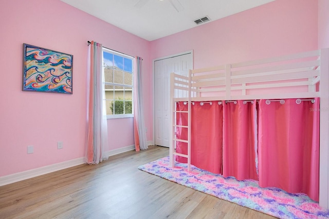 unfurnished bedroom with ceiling fan, a closet, and hardwood / wood-style flooring