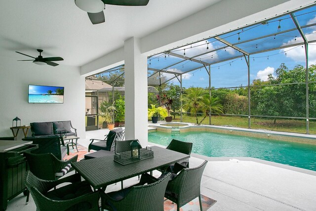 view of swimming pool with glass enclosure, a patio area, ceiling fan, and an in ground hot tub