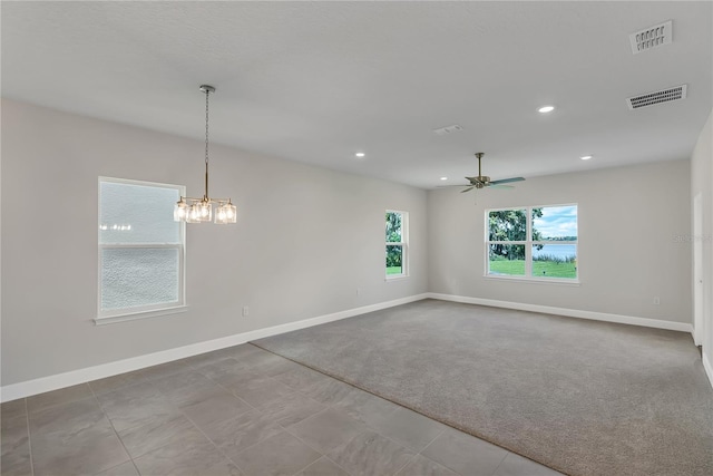 carpeted empty room with ceiling fan with notable chandelier