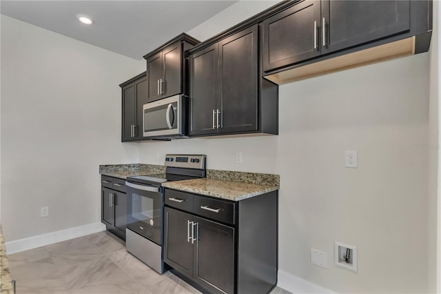 kitchen with light stone countertops, appliances with stainless steel finishes, and dark brown cabinets