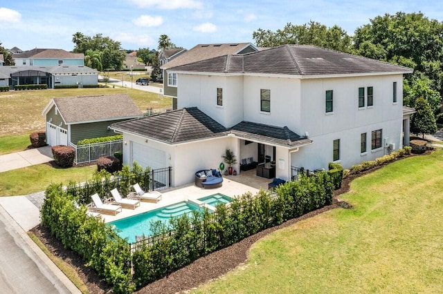 back of property with a yard, a patio, and a garage