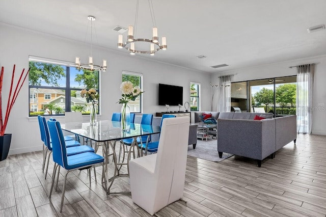 dining area with a wealth of natural light, light wood-type flooring, and an inviting chandelier