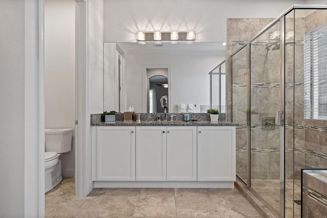 bathroom with vanity, toilet, and a shower with door