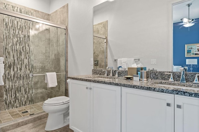 bathroom with vanity, ceiling fan, toilet, and a shower with shower door