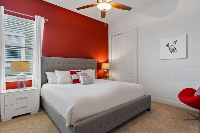 bedroom featuring ceiling fan, a closet, and light colored carpet