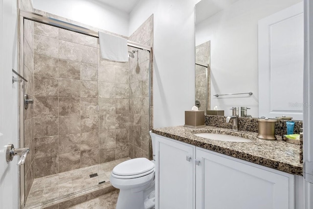 bathroom featuring vanity, toilet, and a shower with door