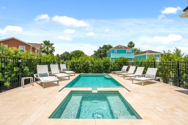 view of swimming pool featuring a patio area and an in ground hot tub