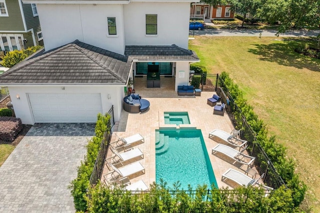 back of property featuring outdoor lounge area, a garage, and a patio area