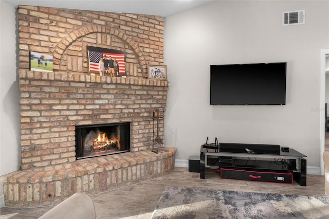 living room featuring hardwood / wood-style flooring, lofted ceiling, and a brick fireplace