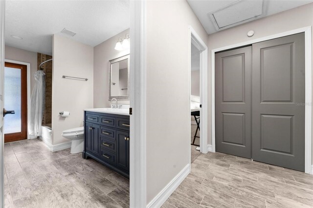 full bathroom featuring hardwood / wood-style flooring, vanity, toilet, and shower / bath combo with shower curtain