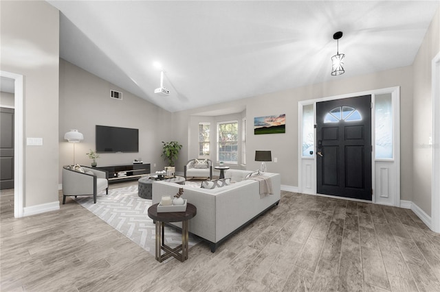 living room with light hardwood / wood-style floors and vaulted ceiling