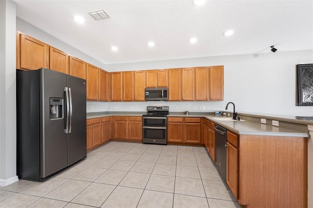 kitchen featuring kitchen peninsula, a textured ceiling, stainless steel appliances, sink, and light tile patterned flooring