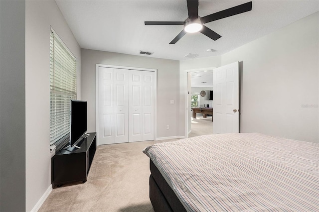 bedroom with light carpet, a closet, and ceiling fan