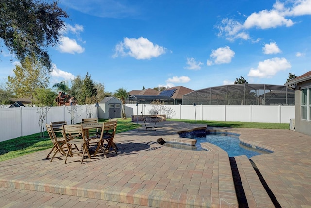 view of swimming pool with a shed, a hot tub, and a patio area