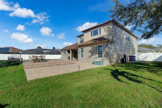 rear view of property featuring a lawn and a patio