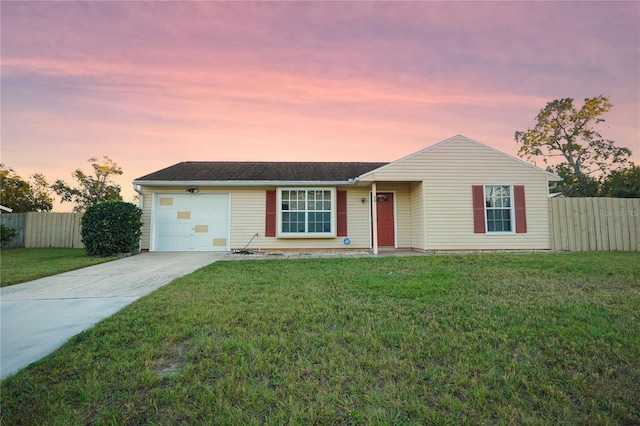 ranch-style house with a garage and a lawn