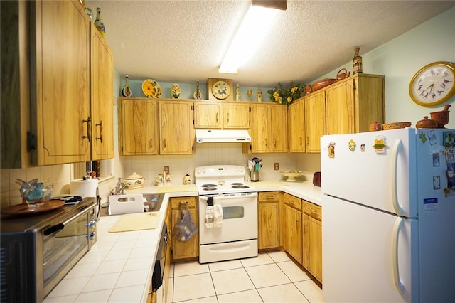 kitchen featuring sink, tasteful backsplash, a textured ceiling, white appliances, and light tile patterned floors