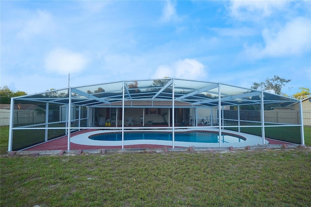 view of swimming pool with glass enclosure and a lawn