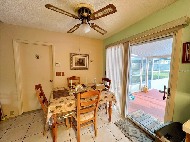 dining space with ceiling fan, light tile patterned flooring, and a textured ceiling