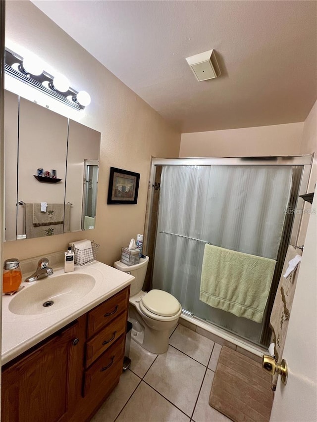 bathroom with tile patterned flooring, a shower, vanity, and toilet