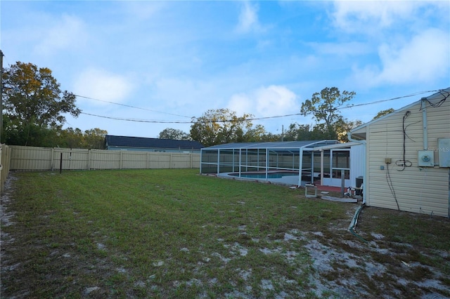 view of yard featuring a fenced in pool and glass enclosure