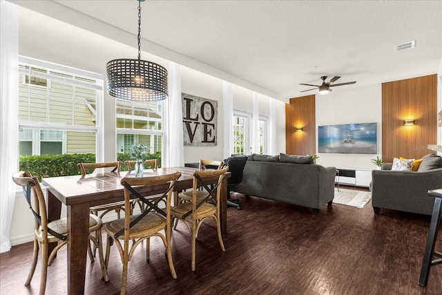 dining space featuring dark hardwood / wood-style floors, ceiling fan, and a textured ceiling